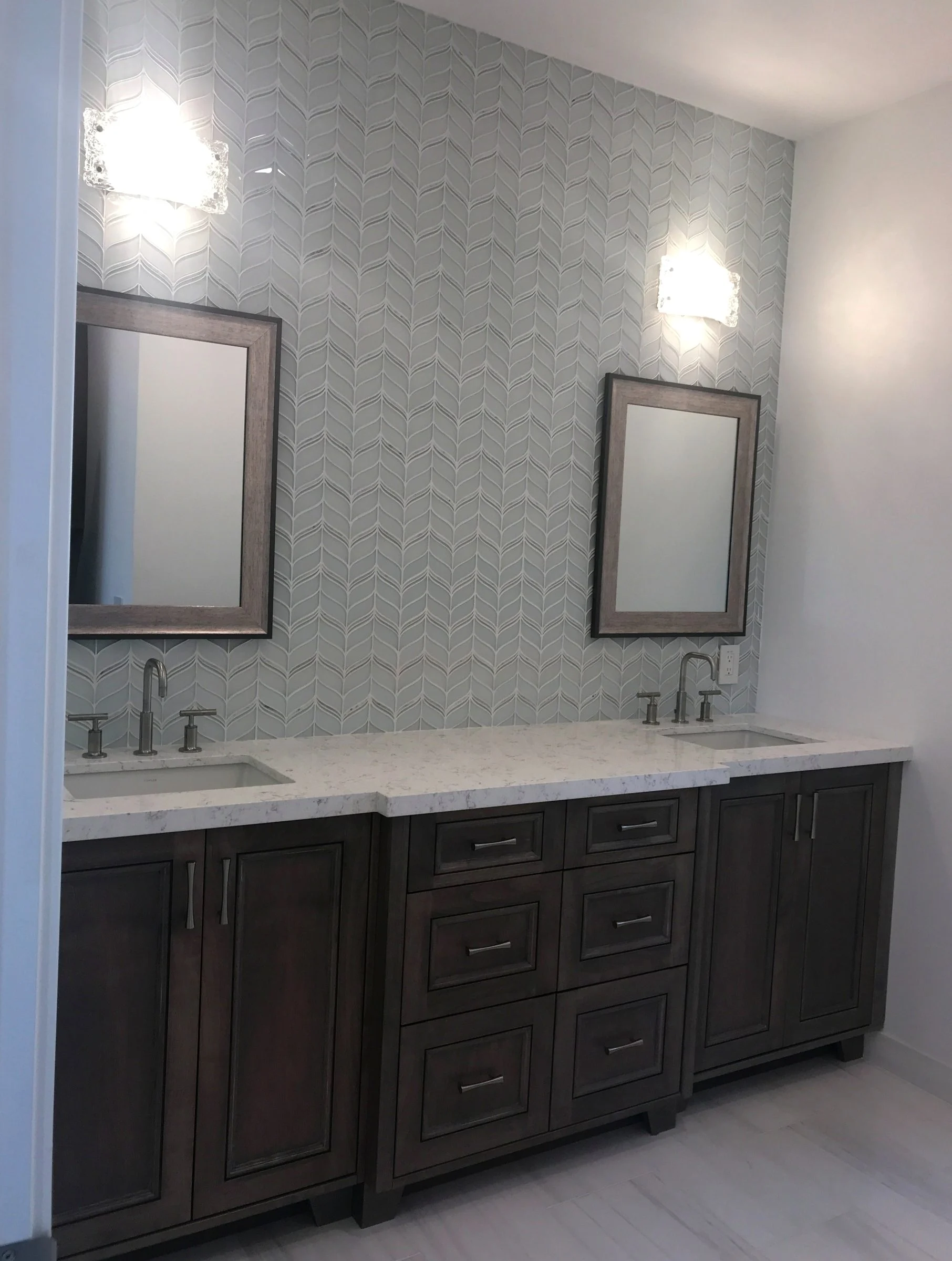 Primary bathroom with a stained double vanity and tile wall